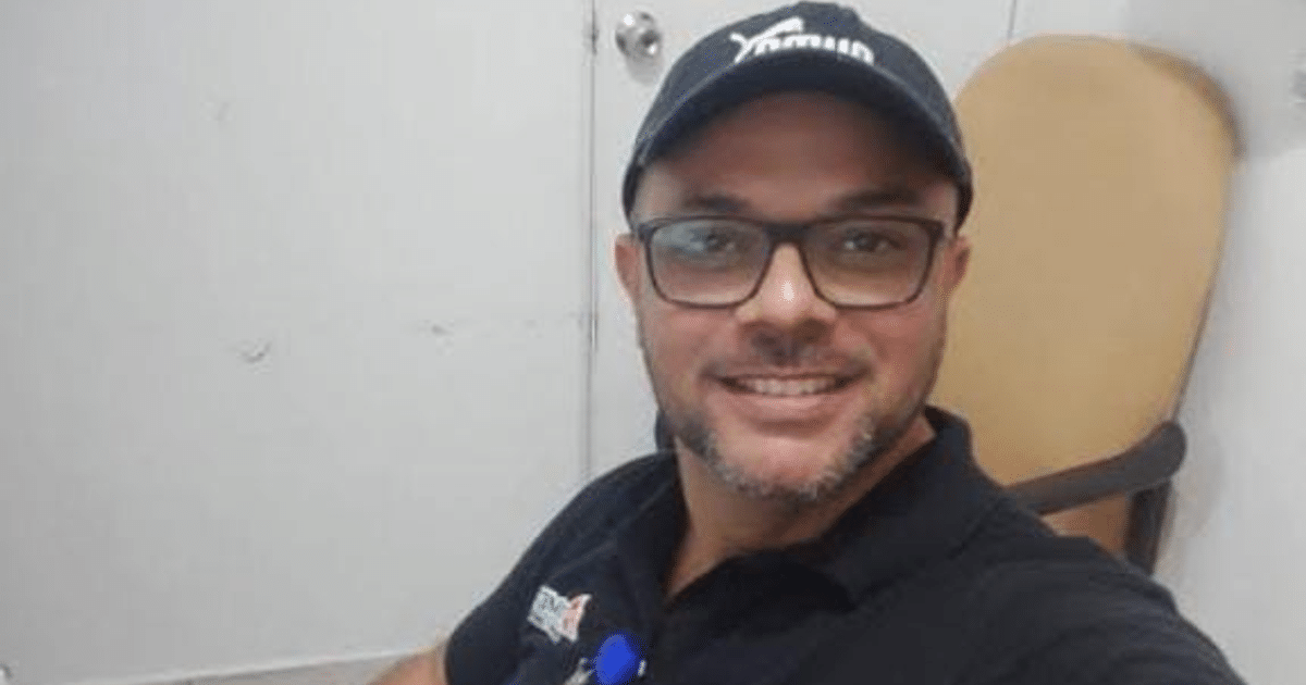 Hombre sonriente con gafas y gorro en oficina, simbolizando resiliencia tras secuestro en Poza Rica