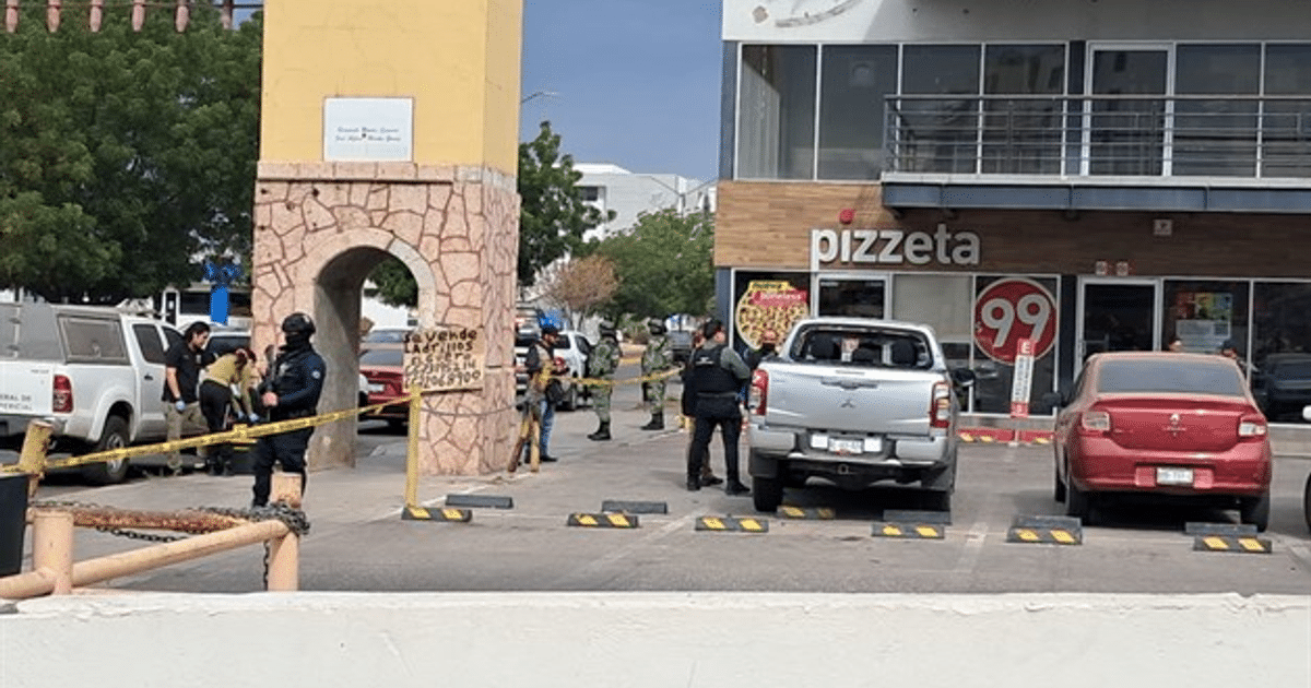 Área urbana con arco, cartel de venta, policías y cinta de seguridad en Culiacán.