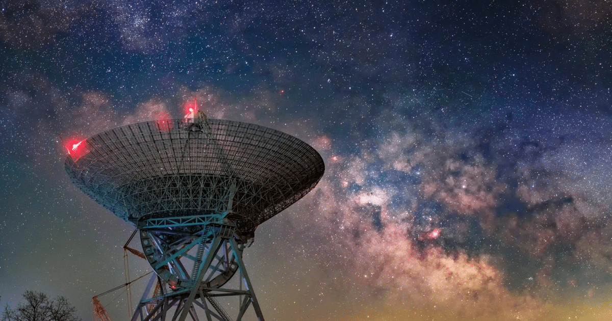Antena de radioastronomía iluminada frente a la Vía Láctea, simbolizando avances en detección de ráfagas de radio.