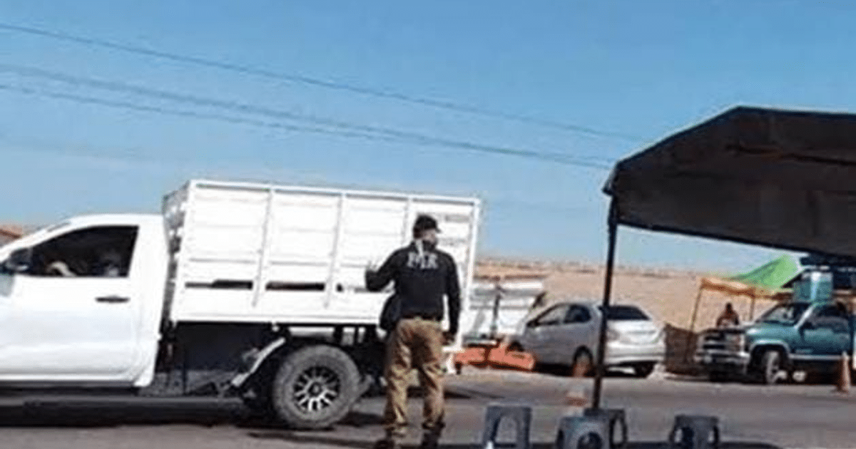 Camioneta blanca y hombre de espaldas en área urbana, posible retén ilegal.