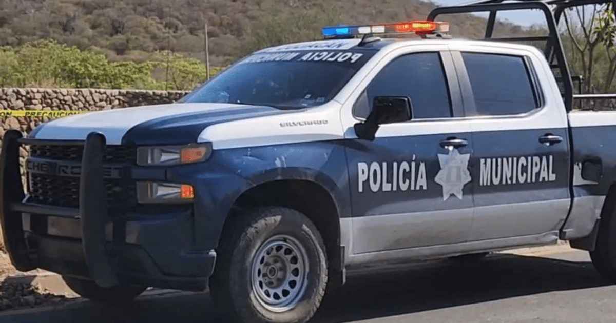 Camioneta de la Policía Municipal con luces rojas y azules en un paisaje natural.