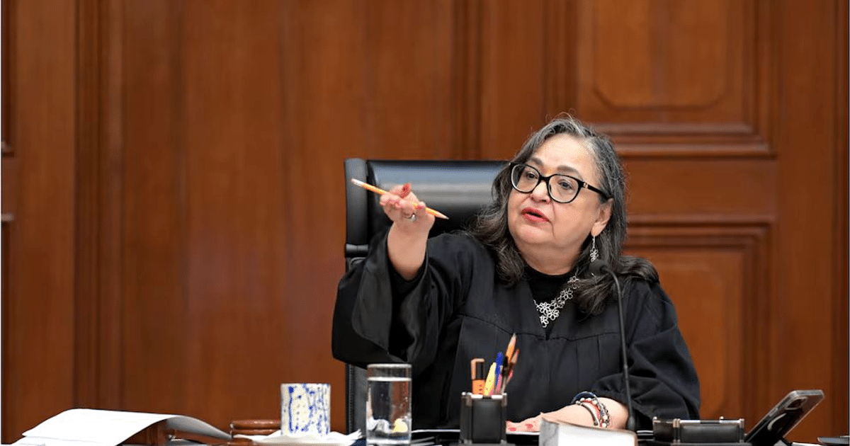 Jueza en tribunal con toga negra levantando un lápiz durante discusión judicial