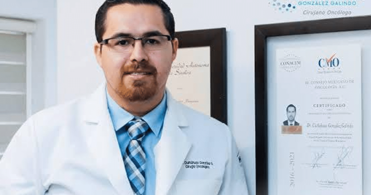 Dr. González Galindo en su consultorio médico con diplomas en la pared, promoviendo la salud masculina en Sinaloa.