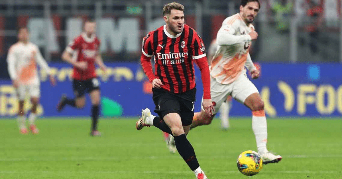 Santiago Giménez corriendo con el balón en su debut con el AC Milan, vistiendo la camiseta de rayas rojas y negras, durante un partido contra la Roma.