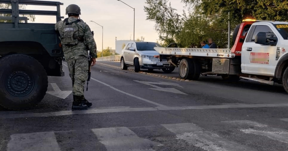 Soldado armado junto a vehículo militar y automóvil remolcado en Culiacán