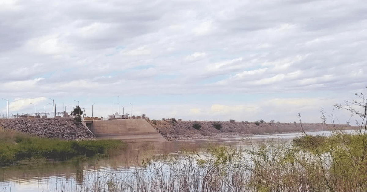 Paisaje con cuerpo de agua, vegetación y estructura de concreto, relacionado con medidas preventivas en presa de Salvador Alvarado.