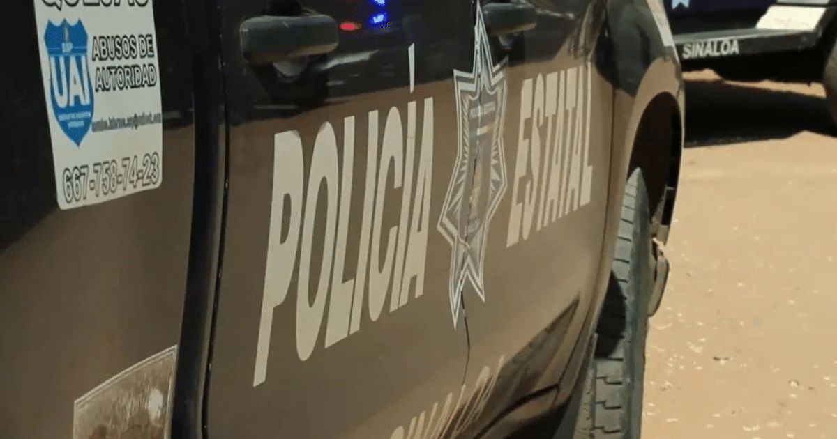 Vehículo de la policía estatal con inscripción visible y etiqueta de contacto, estacionado en área polvorienta.