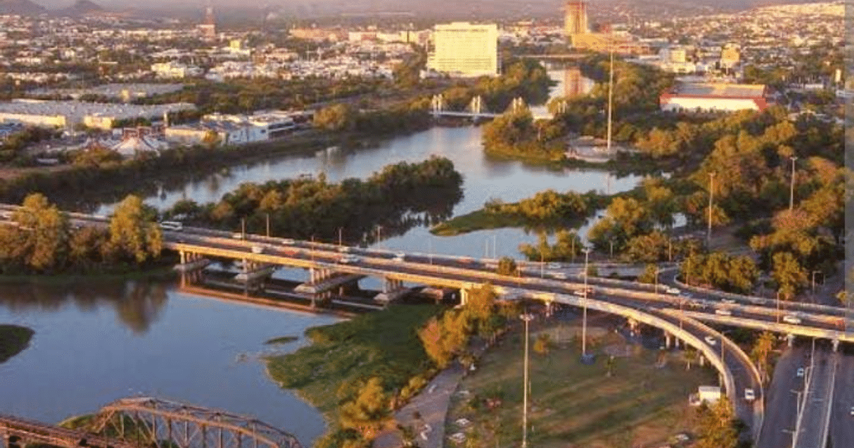 Vista urbana de Culiacán con ríos, puentes y edificios al atardecer