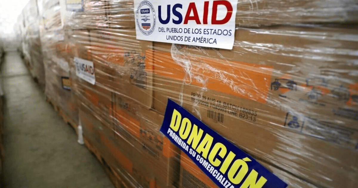 Cajas de donaciones de USAID apiladas con letrero de prohibición de comercialización