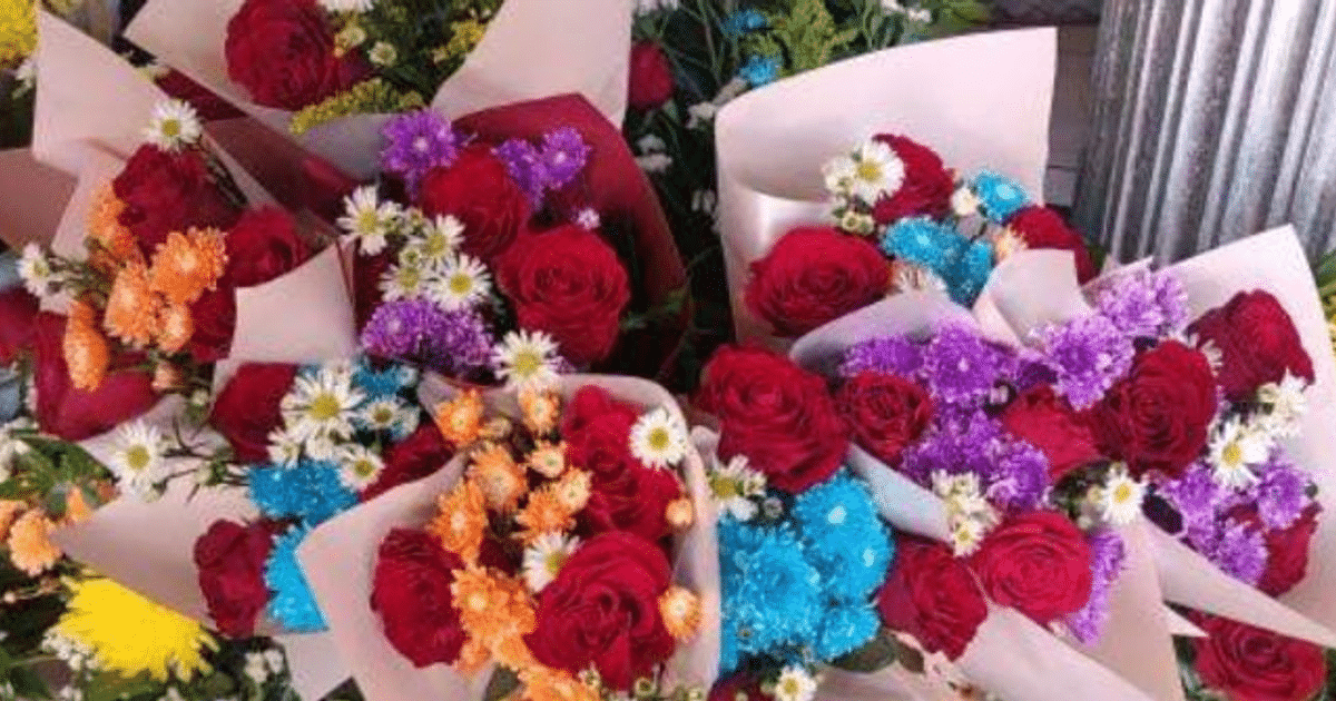 Ramos de flores coloridos con rosas rojas y flores de varios colores en papel claro.