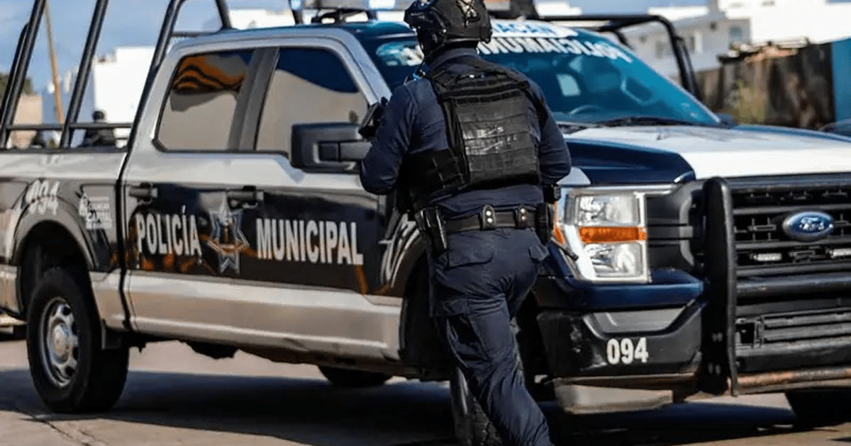 Vehículo de la policía municipal de Culiacán con oficial en chaleco protector en zona urbana.