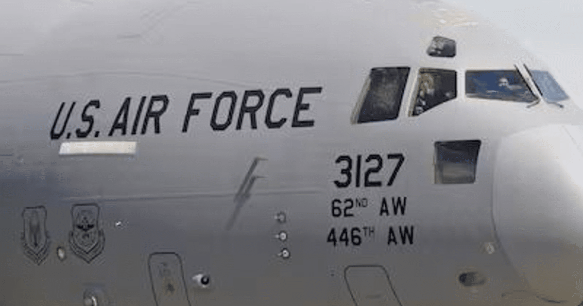 Avión de la Fuerza Aérea de EE.UU. con insignias y piloto visible, parte de la operación de traslado migratorio en Panamá.