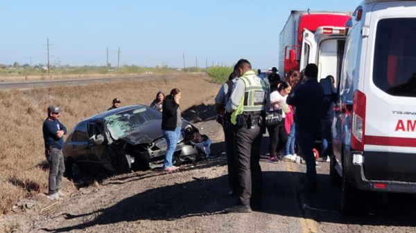 Accidente de tráfico en la Carretera Internacional México 15 con coche negro dañado, personas y ambulancia presentes.