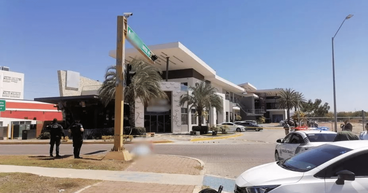 Policías y vehículos en escena urbana de Mazatlán con edificios modernos y cielo despejado.