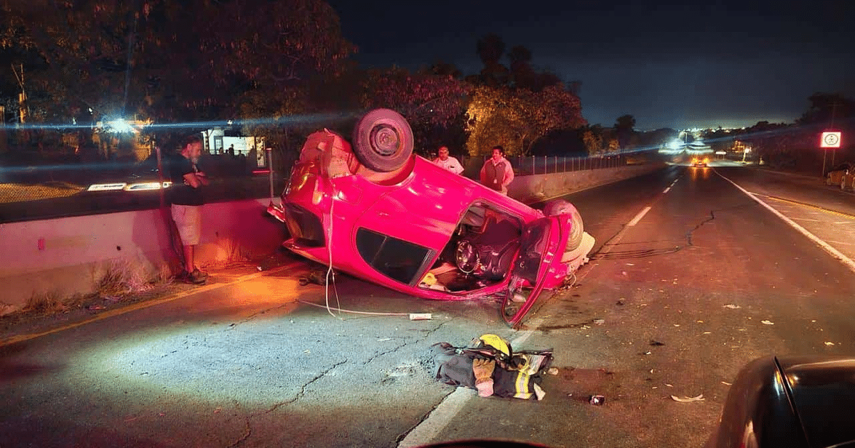 Automóvil volcado en carretera de Mazatlán durante la noche, rodeado de personas y luces de emergencia.