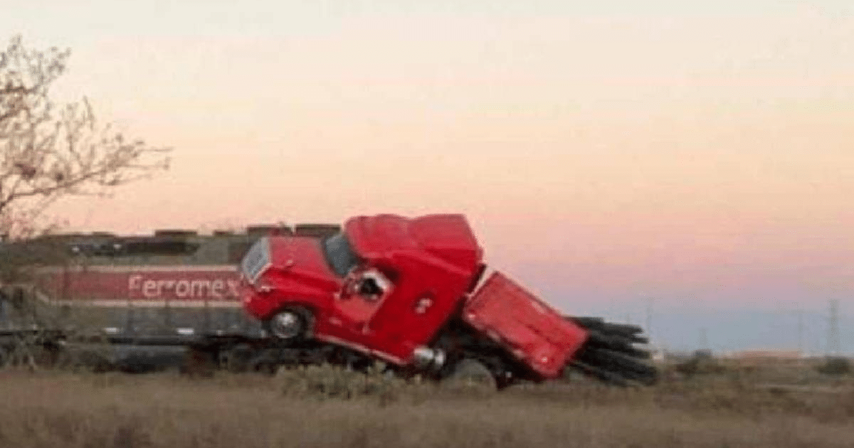 Camión rojo accidentado sobre vagón de tren en Ahome al atardecer