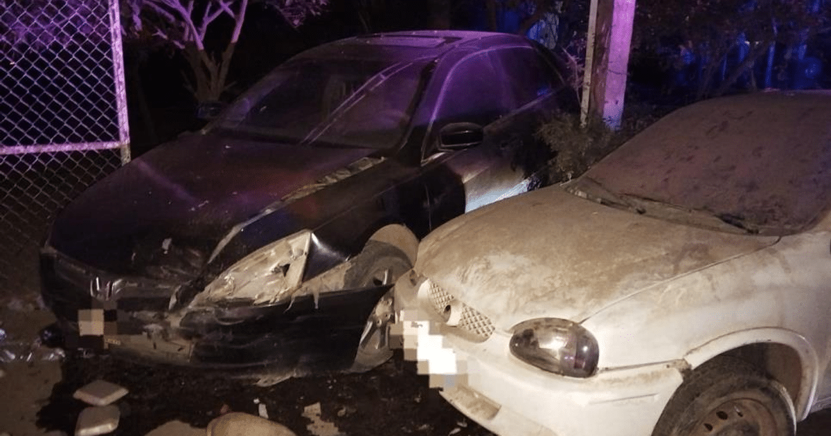 Vehículos dañados tras accidente en San Joaquín, Guasave, con cerca al fondo.