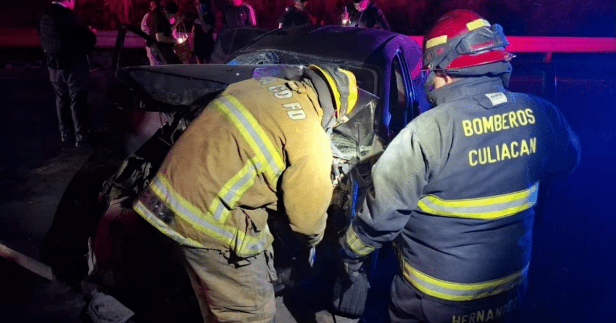 Bomberos trabajando en un accidente automovilístico en Culiacán con luces de emergencia al fondo.