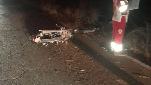 Bicicleta caída en carretera con rescatista en uniforme rojo y blanco