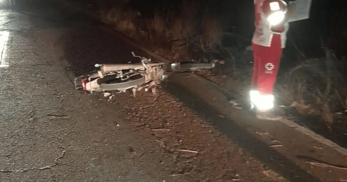 Bicicleta caída en carretera con rescatista en uniforme rojo y blanco