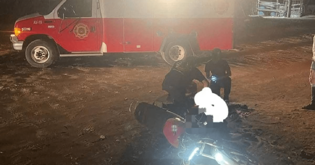 Escena nocturna de rescate en Mazatlán con ambulancia y motocicleta accidentada.