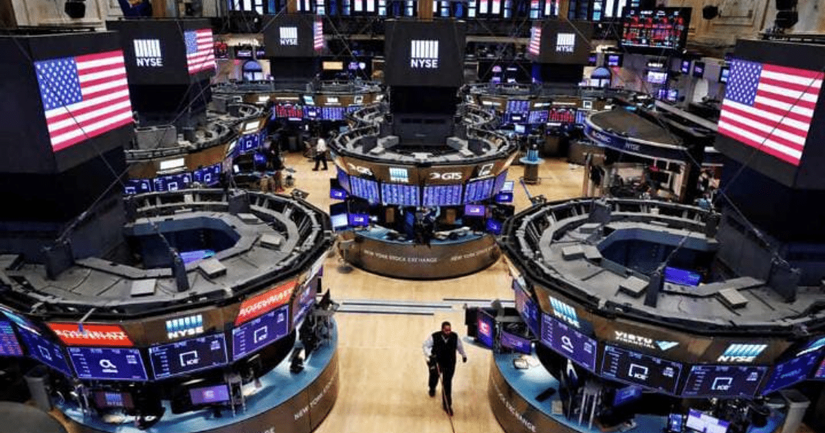 Interior de la Bolsa de Nueva York con pantallas de cotización y banderas de EE.UU.