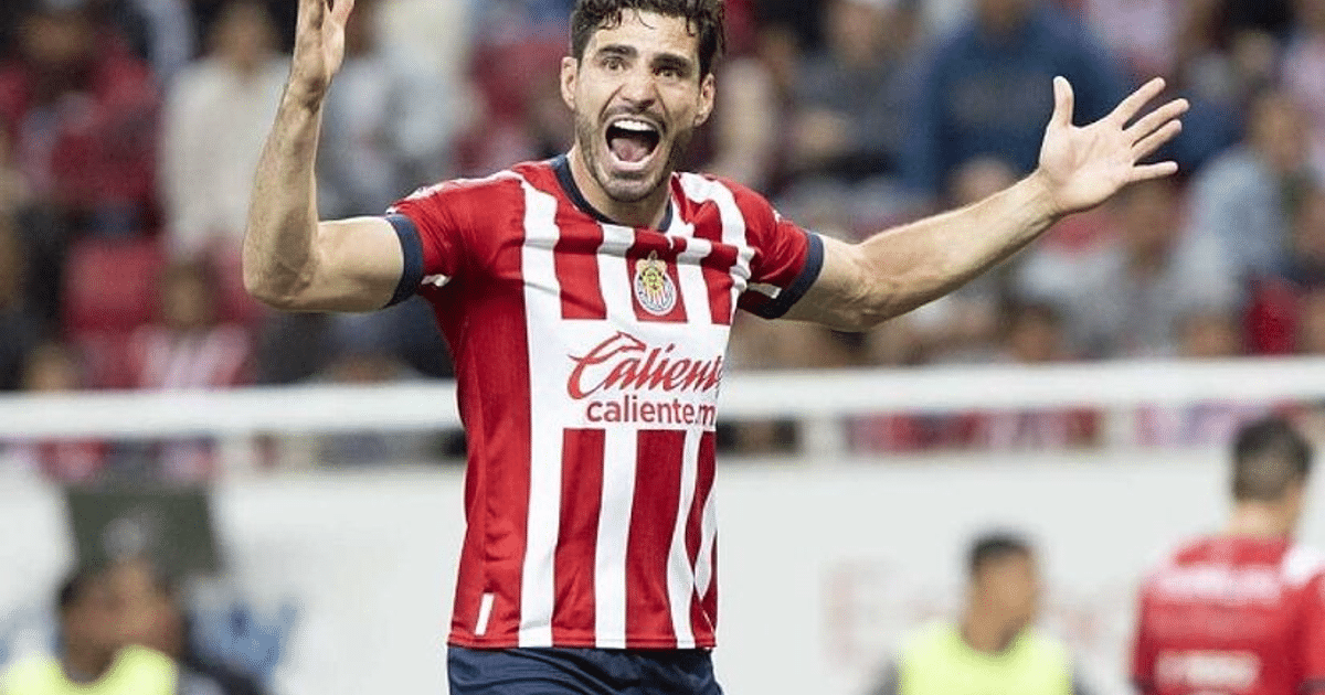 Jugador de fútbol celebrando con camiseta a rayas rojas y blancas en un estadio lleno.