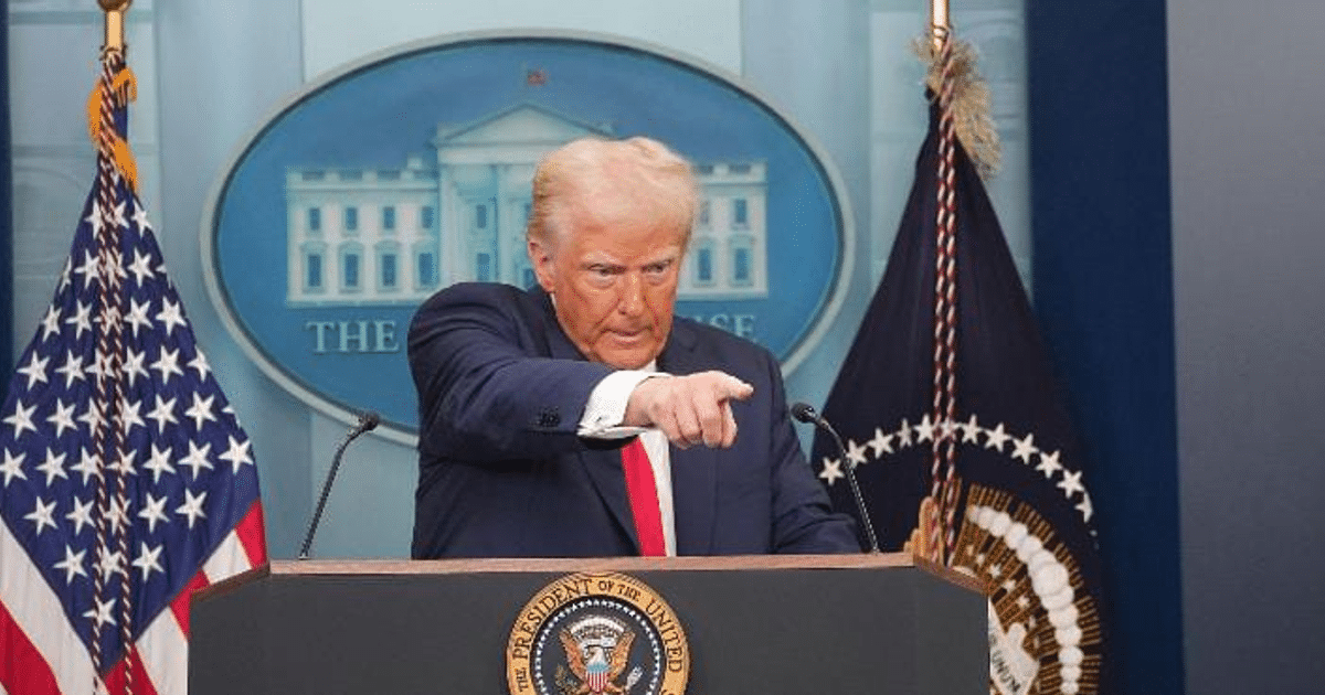 Scott Bessent, Secretario del Tesoro de EE.UU., en conferencia sobre política arancelaria con banderas de fondo.