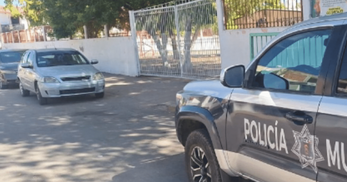 Calle en Culiacán con vehículos estacionados, incluyendo un SUV de la Policía Municipal, en un operativo tras un asalto.