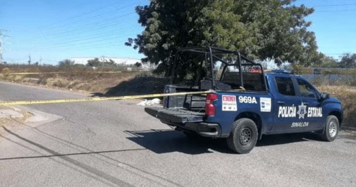 Camioneta de la policía estatal de Sinaloa en una calle acordonada con cinta amarilla.