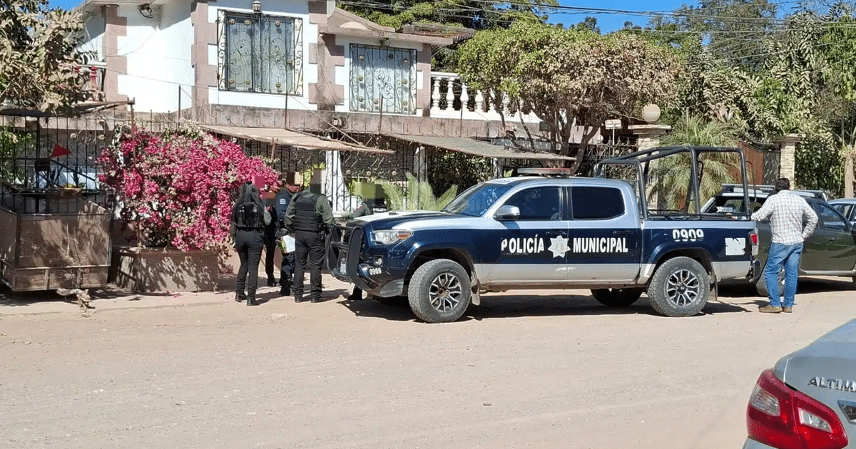 Vehículo policial en Culiacán con oficiales y civiles alrededor, en un día soleado.