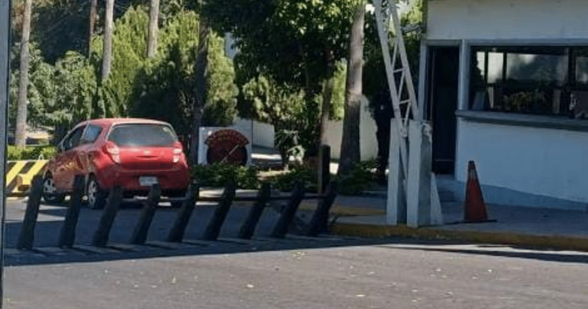 Chevrolet Beat rojo estacionado frente a garita de seguridad en Culiacán, Sinaloa, tras incidente violento.