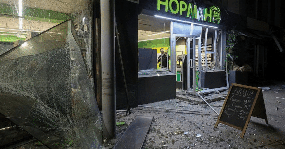 Local comercial dañado con entrada rota, escombros y letrero en cirílico, tras un violento ataque con drones en Ucrania