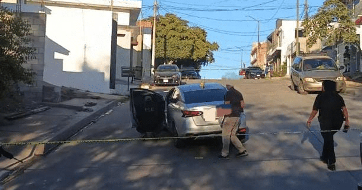 Agentes de seguridad investigan un Nissan Versa gris con daños en Culiacán.