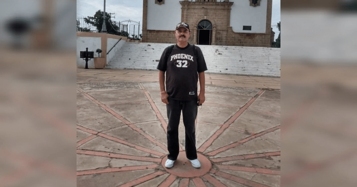 Hombre con camiseta 'PHOENIX' número 32 frente a escaleras de iglesia o monumento en día nublado.