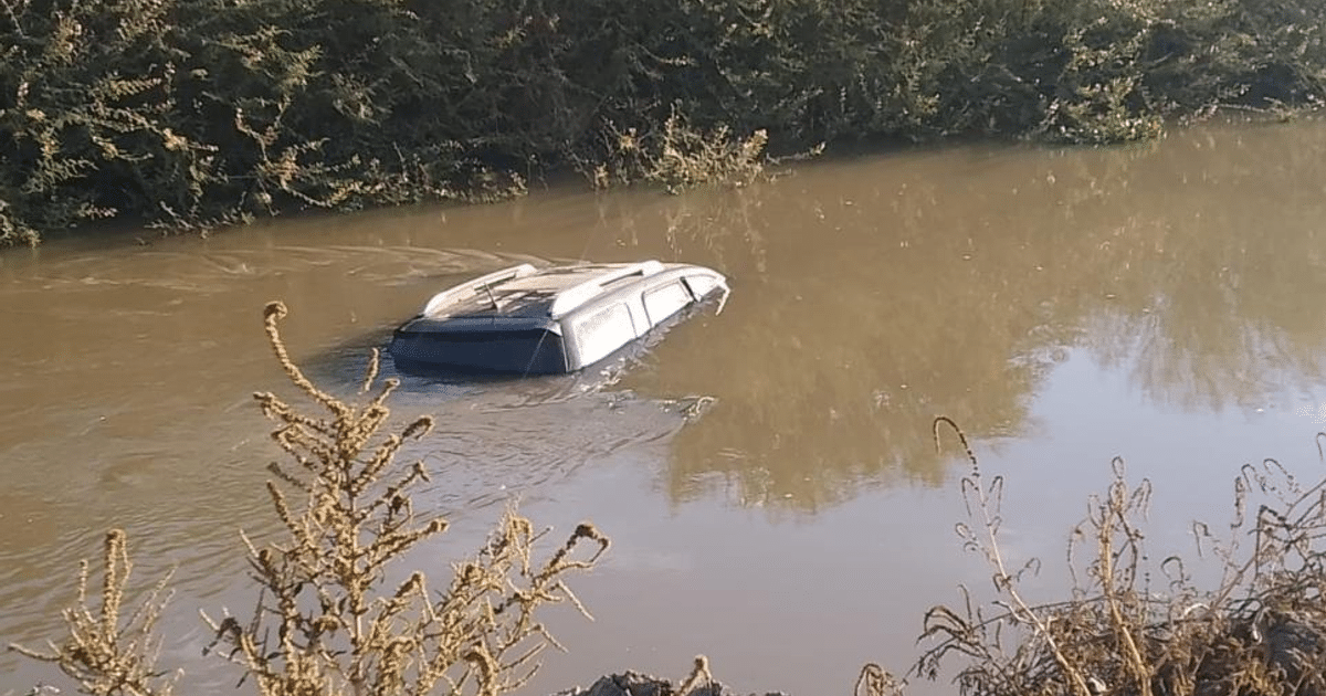 Camioneta sumergida en canal con agua turbia y vegetación alrededor en Culiacán.