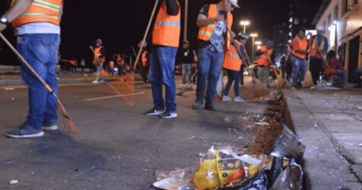 Trabajadores limpiando una calle durante la noche en el Carnaval Internacional Mazatlán 2025