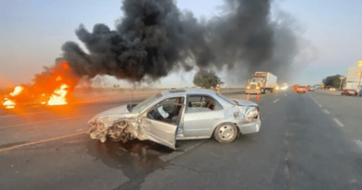 Accidente automovilístico en la carretera México 15 con coche incendiado y humo negro.