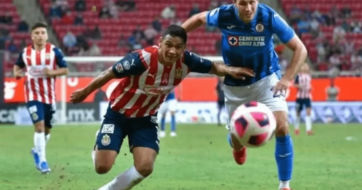 Jugadores de Chivas y Cruz Azul disputan el balón en el partido Clausura 2025, con gradas vacías de fondo.