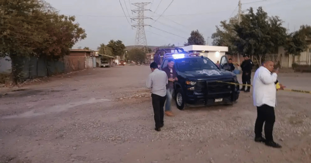 Vehículo policial con luces encendidas y agentes en escena de crimen en Culiacán