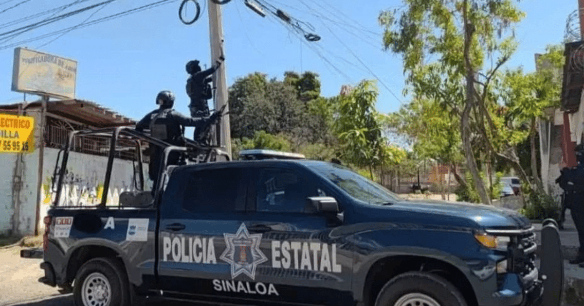 Camioneta de la policía estatal de Sinaloa con agentes inspeccionando cámaras de videovigilancia.