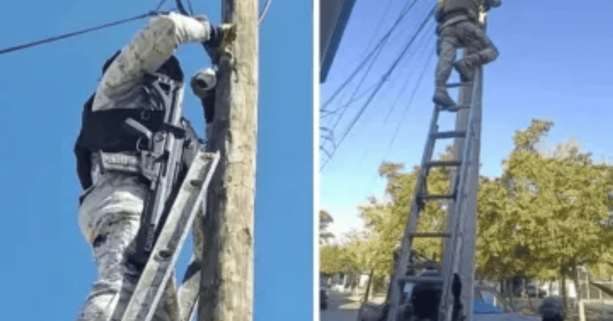 Agente de seguridad en Sinaloa retirando cámara de vigilancia de un poste.
