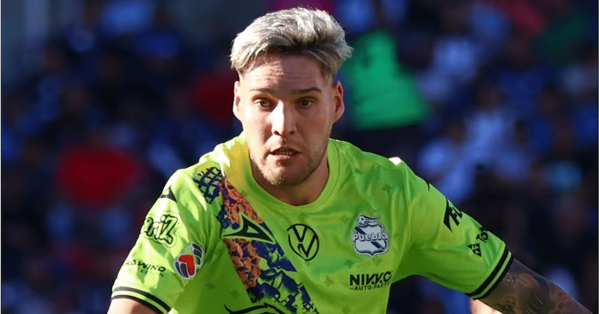 Emiliano Gómez, jugador de fútbol del club Puebla, en acción durante un partido, vistiendo una camiseta amarilla brillante.