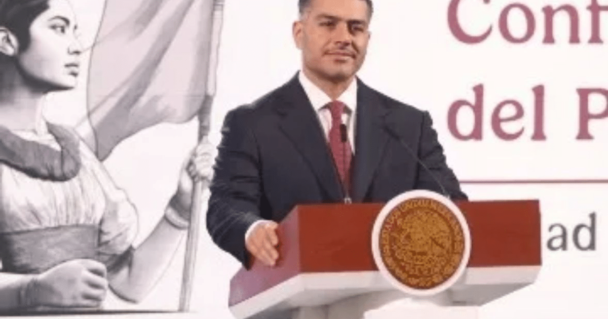 Hombre en podio dando discurso sobre seguridad nacional con ilustración de mujer con bandera al fondo.