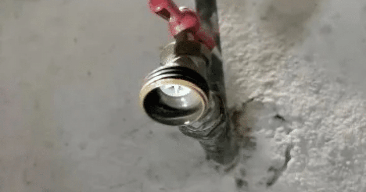 Válvula de cierre roja en sistema de plomería, relacionada con corte de agua en Mazatlán.