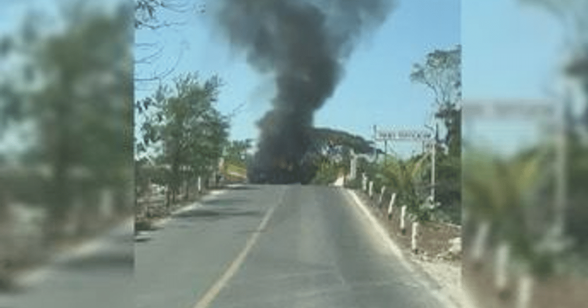 Vehículo en llamas en carretera de Jalisco con humo negro y vegetación alrededor.