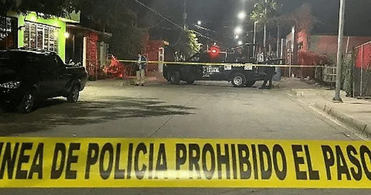 Escena nocturna de Culiacán con cinta de 'PROHIBIDO EL PASO' y patrulla policial.