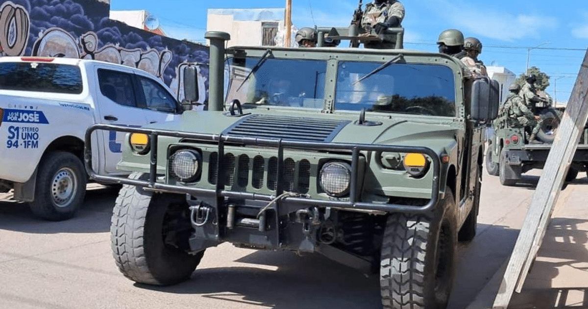 Humvee militar verde en operativo en Mazatlán junto a camioneta de medios de comunicación.