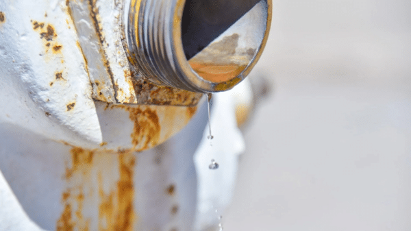 Válvula metálica oxidada con goteo de agua, representando la crisis hídrica en Ahome.