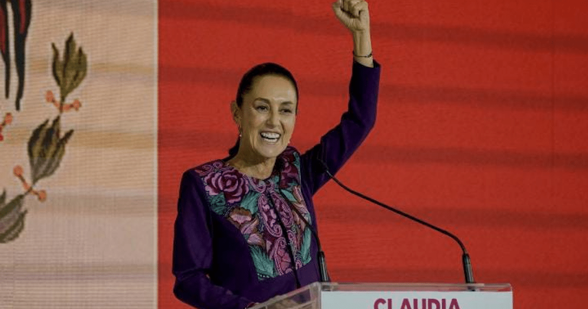 Claudia Sheinbaum levantando el brazo en señal de triunfo en la ceremonia de Caintra